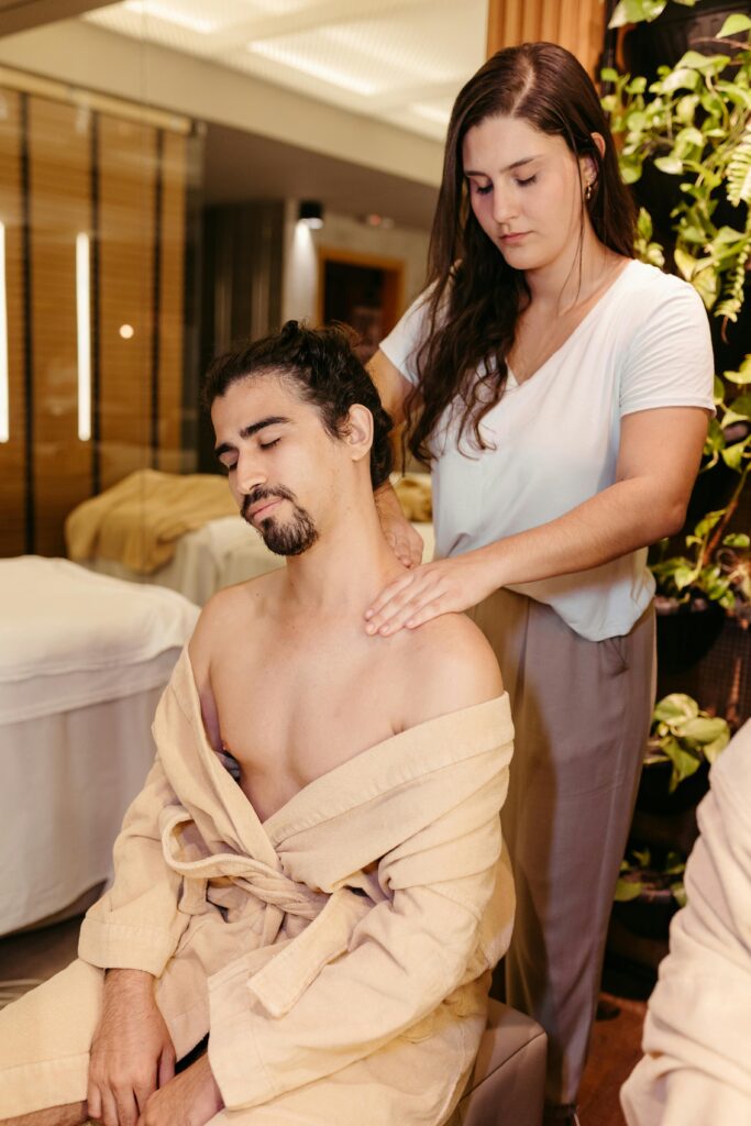A man enjoying a relaxing massage by a therapist in a tranquil spa setting.